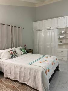 um quarto com uma cama branca e um armário branco em MBS Travel Holistic Guest House em Mammee Bay