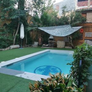 a swimming pool with a hammock in a yard at Caltarragona casa rural in Miralcamp