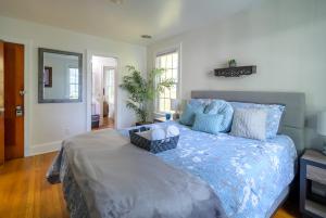 Schlafzimmer mit einem Bett mit blauer Decke und einem Spiegel in der Unterkunft Retro Bungalow A Block to Tennis Courts & Park in Richmond