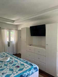 a bedroom with a bed and a tv on a wall at Bequia Plantation Hotel in Bequia