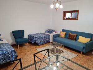 sala de estar con sofá azul y silla en Casa Valente, en Macedo de Cavaleiros