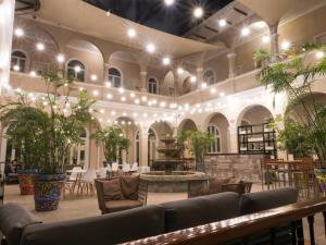 une grande chambre avec des tables, des chaises et des plantes dans l'établissement LP Los Portales Hotel Piura, à Piura