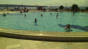 a group of people swimming in a swimming pool at Apartments Cindrić in Selce