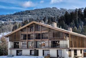 a large wooden house with a mountain in the background at Chalet Esquinade 4 bedrooms appartment Megève in Megève