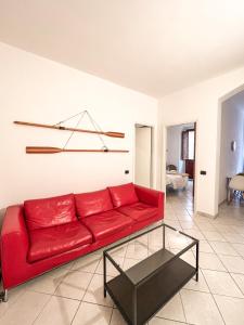 een rode bank in een woonkamer met een tafel bij Bacans - Via Azuni in Cagliari