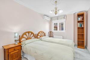 a bedroom with two beds and a table with a lamp at PISO EN CALLE ARABIAL, JUNTO A EL CORTE INGLÉS in Granada
