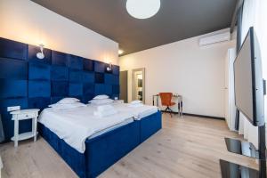 a bedroom with a large bed with a blue headboard at Zero in Cluj-Napoca