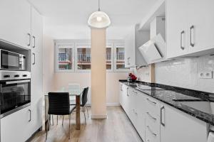 a kitchen with white cabinets and a table and chairs at PISO EN CALLE ARABIAL, JUNTO A EL CORTE INGLÉS in Granada