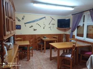 Casa Rural Felip في إيسبوت: غرفة طعام مع طاولات وتلفزيون على الحائط