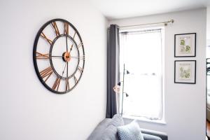 una sala de estar con un reloj grande en la pared en REEF7 - Modern central flat, 5 mins from beach, centre and Bournemouth International Centre, en Bournemouth