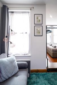 uma sala de estar com um sofá e uma janela em REEF7 - Modern central flat, 5 mins from beach, centre and Bournemouth International Centre em Bournemouth