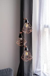 a group of three lights hanging from a wall at REEF7 - Modern central flat, 5 mins from beach, centre and Bournemouth International Centre in Bournemouth