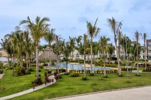 un complexe avec une piscine et des palmiers dans l'établissement Acapulco diamante, club de playa privado, canchas pádel para 8 huéspedes, à Acapulco