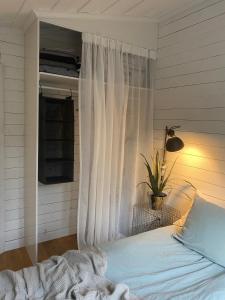 a bedroom with a bed with a white curtain at Peaceful and Scandinavian-style Guesthouse with Scenic Nature and Seaview in Domsjö