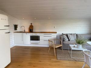een keuken en een woonkamer met een bank en een tafel bij Peaceful and Scandinavian-style Guesthouse with Scenic Nature and Seaview in High Coast in Domsjö