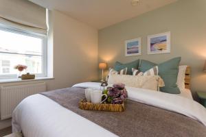 Un dormitorio con una cama con una bandeja de flores. en Stunning Sea View Central Torbay Home with Parking en Torquay