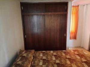 Schlafzimmer mit einem Bett und einer Holztür in der Unterkunft HOSTAL LARA in Arequipa