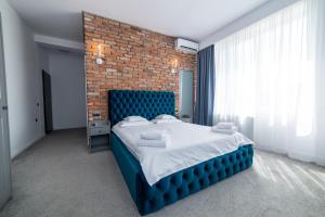 um quarto com uma cama azul e uma parede de tijolos em Zero em Cluj-Napoca