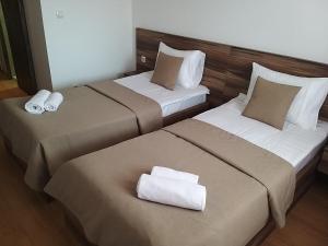 two beds in a hotel room with towels on them at Prenoćište SRBIJA in Surdulica