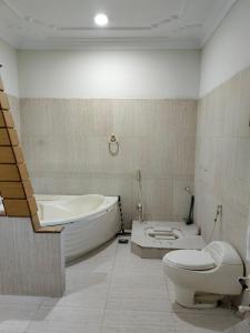 a bathroom with a tub and a toilet and a sink at Karachi Family Guest House in Karachi