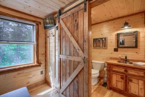 baño con puerta de madera en una cabaña de madera en Seven Pines Cabin - Secluded in Hocking Hills, en Nelsonville