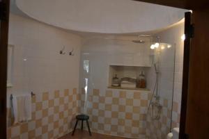 une salle de bain avec une douche aux murs carrelés et un tabouret dans l'établissement La casa vieja de la Montaña, à Santa Lucía 34 autres photos