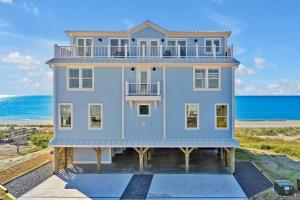 een huis aan het strand met de oceaan op de achtergrond bij La Vita Bella in Oak Island