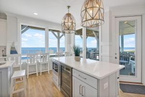 een keuken met witte kasten en een tafel en stoelen bij La Vita Bella in Oak Island