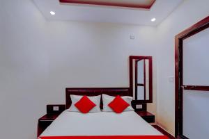 een slaapkamer met een bed met rode kussens bij Flagship Hotel Days Inn in Rānchī