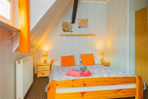 a bedroom with a wooden bed with orange pillows at PROMYK - Apartamenty & Pokoje - dla dorosłych in Białogóra