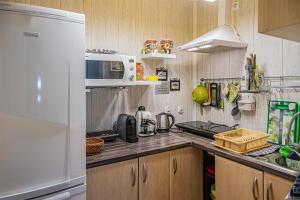 a kitchen with a white refrigerator and a sink at PROMYK - Apartamenty & Pokoje - dla dorosłych in Białogóra