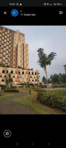 a picture of a building with a tree in a park at Studio Healing Sayana Apartment in Tambun-lobangbuaja