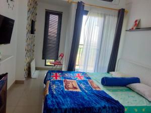 a bedroom with a bed with a blue comforter at Studio Healing Sayana Apartment in Tambun-lobangbuaja