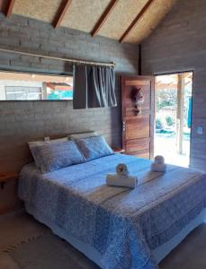 a bedroom with a bed with a blue comforter at Chalé na Montanha in Santo Antônio do Pinhal