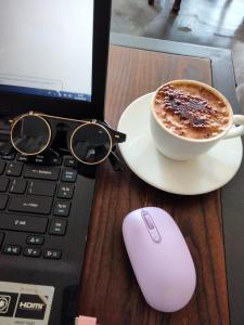uma chávena de café, um rato e um computador portátil em Studio Healing Sayana Apartment em Tambun-lobangbuaja