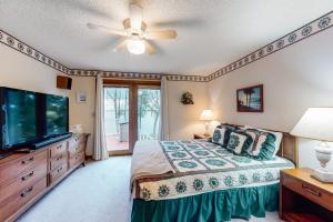 een slaapkamer met een bed en een flatscreen-tv bij Grand Isle Lake House in Grand Isle