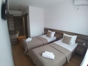 una camera d'albergo con due letti con cuscini bianchi di Prenoćište SRBIJA a Surdulica