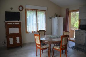 a kitchen with a dining room table and chairs at LE HOME FLEURI MLD in Ménesplet