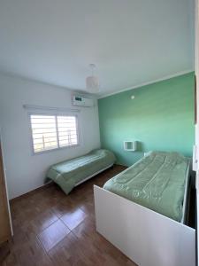 - une chambre avec 2 lits et une fenêtre dans l'établissement Caelum, à Concepción del Uruguay