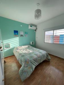 - une chambre avec un lit et un mur bleu dans l'établissement Caelum, à Concepción del Uruguay