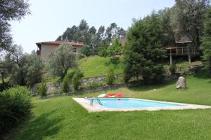a swimming pool in a yard with a house in the background at Casas do Corvo in Ventosa