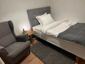 a bedroom with a bed and a chair next to a table at Unik BnB midt i byen - mad event og bilopladning in Herning