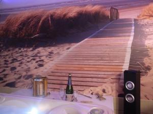 einen Tisch mit einer Flasche Wein am Strand in der Unterkunft LOVE SPA in Oye-Plage