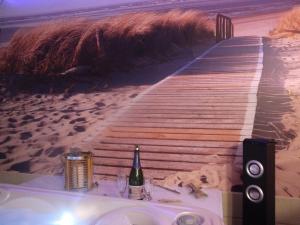 un tavolo con una bottiglia di vino sulla spiaggia di LOVE SPA a Oye-Plage