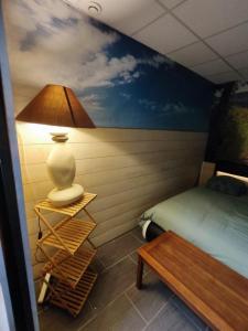 a bedroom with a bed and a lamp and a table at LOVE SPA in Oye-Plage