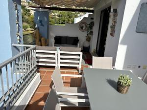 uma varanda com uma mesa branca e cadeiras em Penthouse Los Arqueros golf em Benahavís