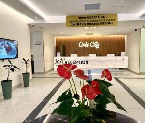 lobby z czerwonymi kwiatami przed poczekalnią w obiekcie Luxury Aparthotel orbi in black sea arena w mieście Batumi