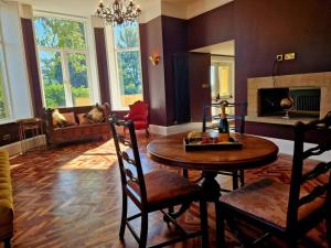 a living room with a table and a fireplace at The Hamilton Luxury Let-The Duke in Scorton
