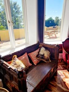 un divano con cuscini in una stanza con finestre di The Hamilton Luxury Let-The Duke a Scorton