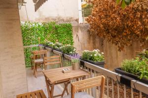 um pátio com mesas, cadeiras e vasos de plantas em 3bd jacuzzi mansion em Atenas